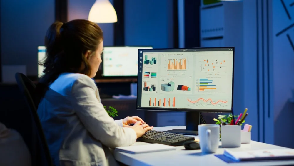 busy woman working night front computer taking notes writing notebook annual reports checking financial project focused employee using technology network wireless doing overtime job min